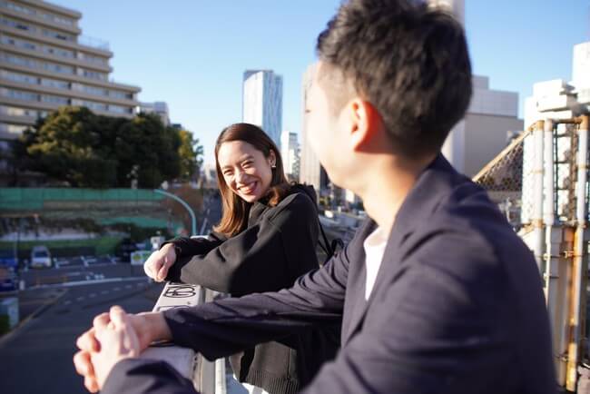 笑顔の女性と女性の方を向いている男性